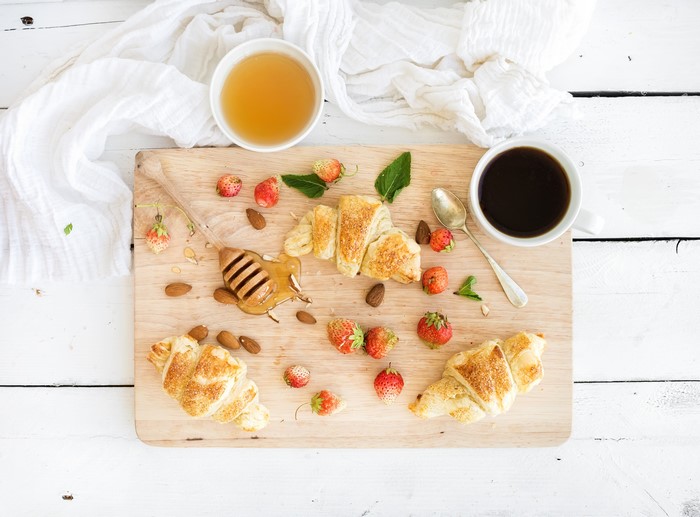 Breakfast with Croissants, Strawberries, Honey, and Coffee