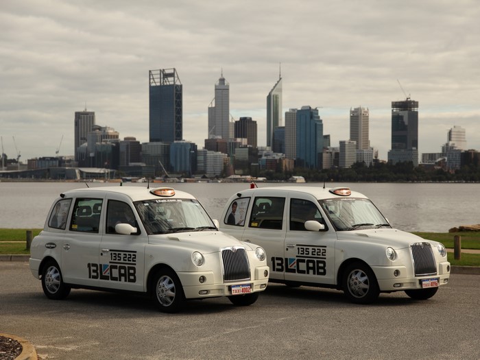 Two white London Taxis with Perth skyline in background