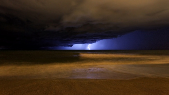 Lightning strike over the ocean at night