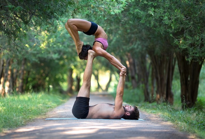 Two people doing acro yoga in a park