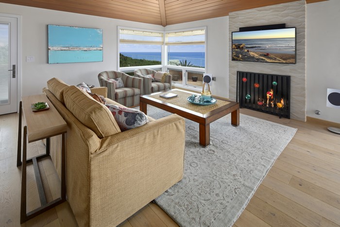 Living room with sofa, table, and ocean view