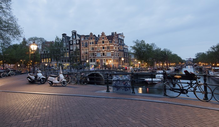 Amsterdam canal with houses and bridges in the evening