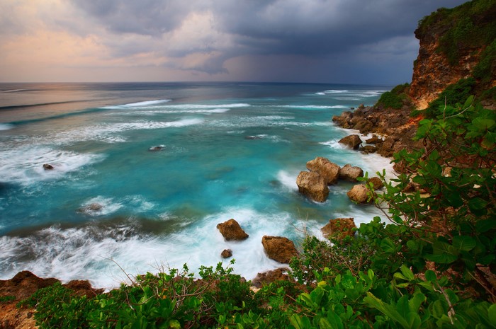 Ocean waves crashing on rocky coast of Bali, Indonesia