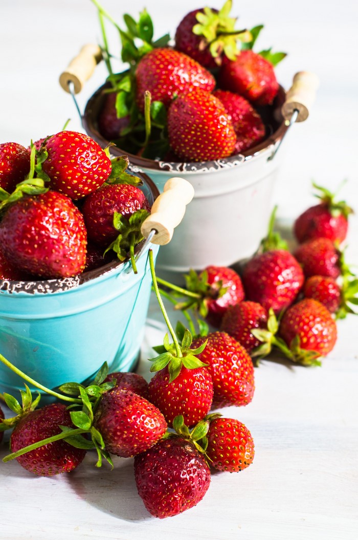 Strawberries in buckets on a white background