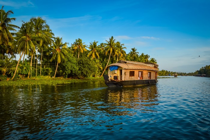 Houseboat on a river in Kerala, India with palm trees