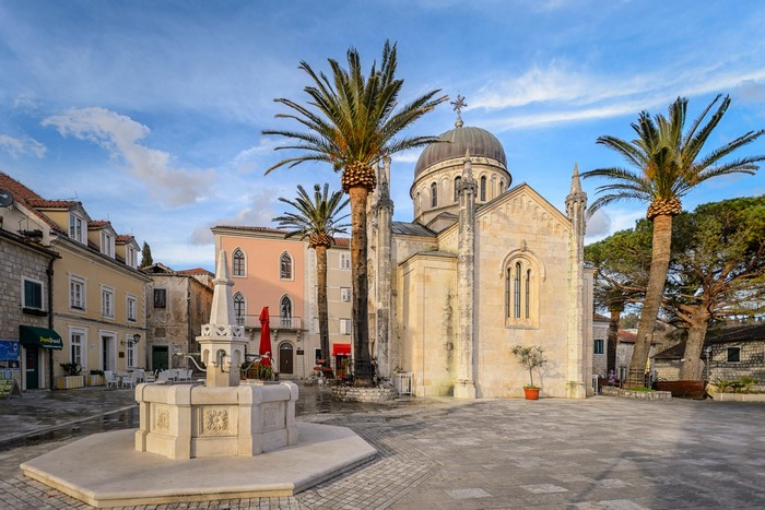 Church and fountain in Herceg Novi, Montenegro with palm trees