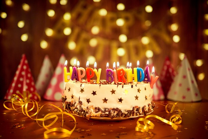 Birthday cake with candles and party hats