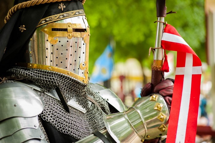 Knight in full armor holding a flag