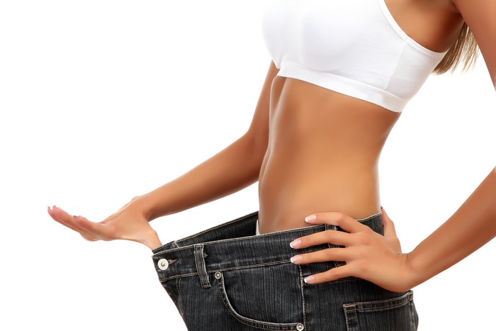 Woman in oversized jeans on white background