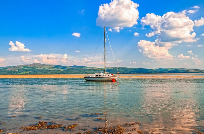 Sailboat anchored in a bay with mountains in the background