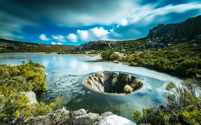 Frozen lake with a sinkhole in Sabugueiro, Portugal