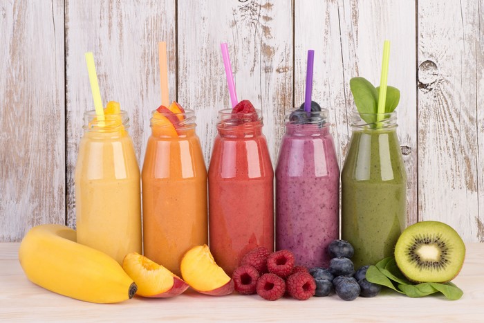 Assortment of Fruit Smoothies in Bottles with Fresh Fruit