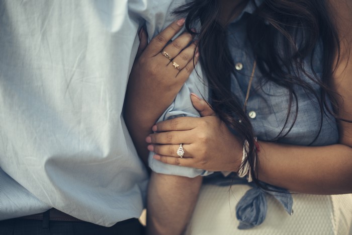 Couple's hands with engagement ring