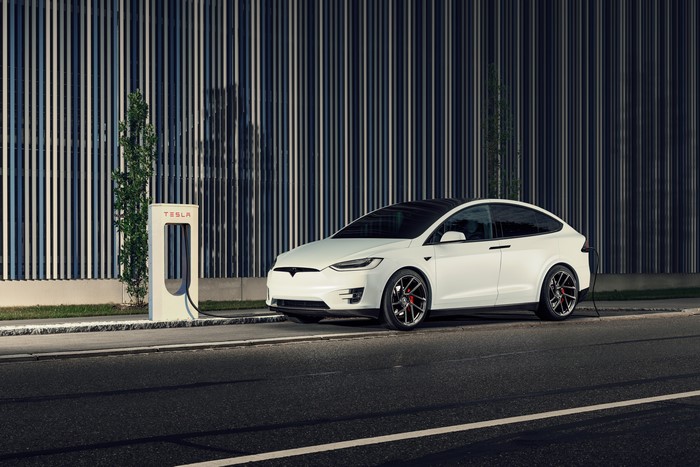 White Tesla Model X charging at Tesla station