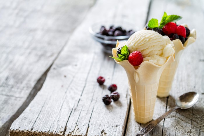 Ice cream cones with berries on wood planks