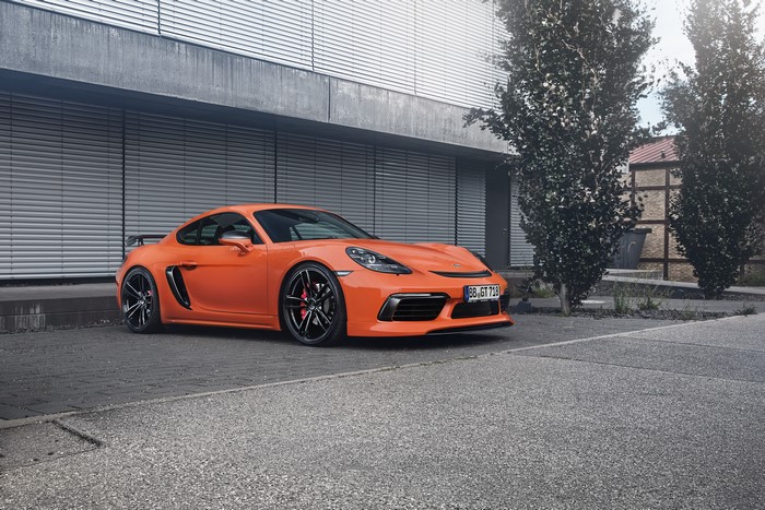 Orange TechArt 718 Cayman Porsche parked outside building