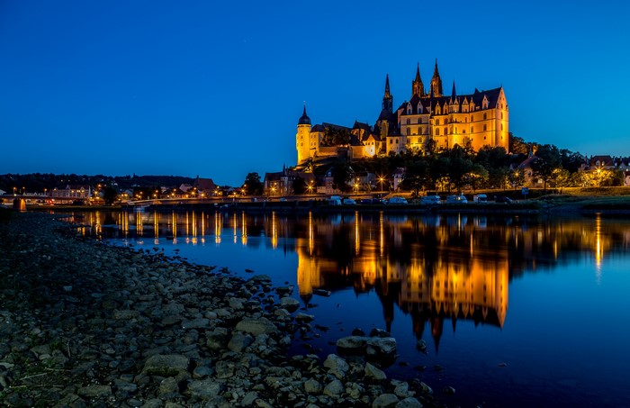 Albrechtsburg Castle reflected in river at dusk