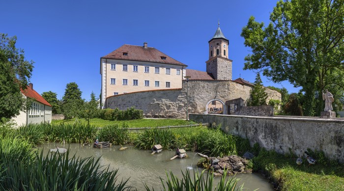 Monastery building with tower and pond in Gosheim, Germany