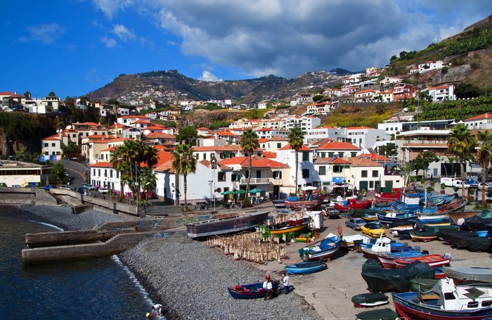 Boats docked in a coastal town on a hillside in Madeira, Portugal