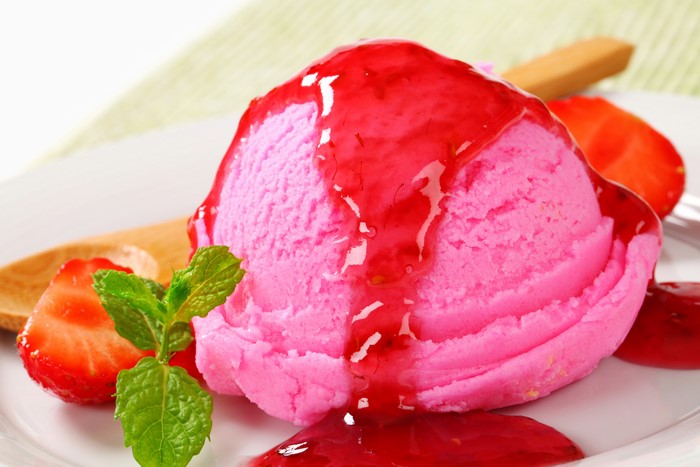 Pink ice cream with strawberry jam and strawberries
