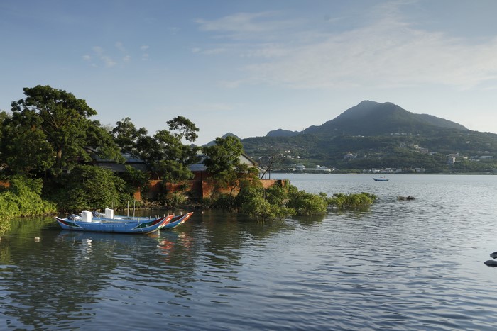 Boats on a river with mountains in the background