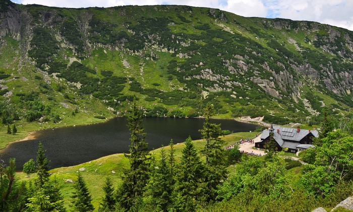 Mountain lake with a house and spruce trees in Poland