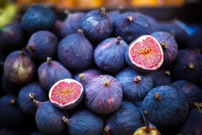 Pile of fresh purple figs, one cut in half
