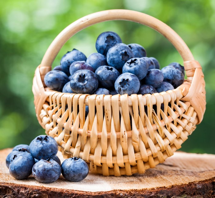 Blueberries in a wicker basket on wood