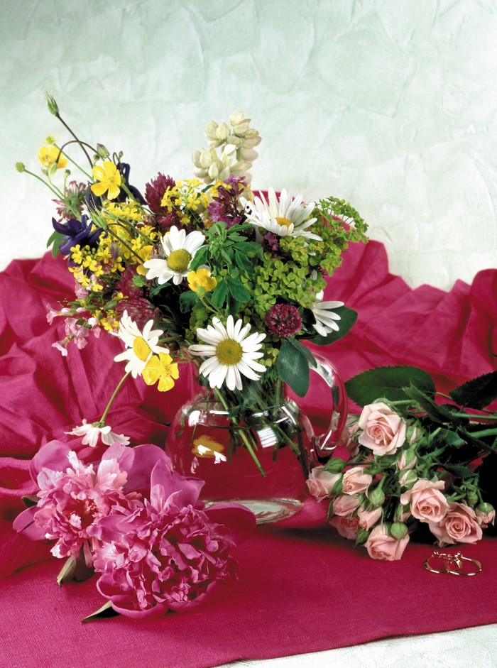 Bouquet of wildflowers, peonies, roses, and rings in a vase