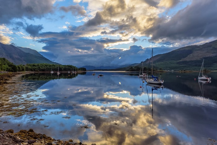 Sailboats on Loch Leven, Scotland under cloudy sky