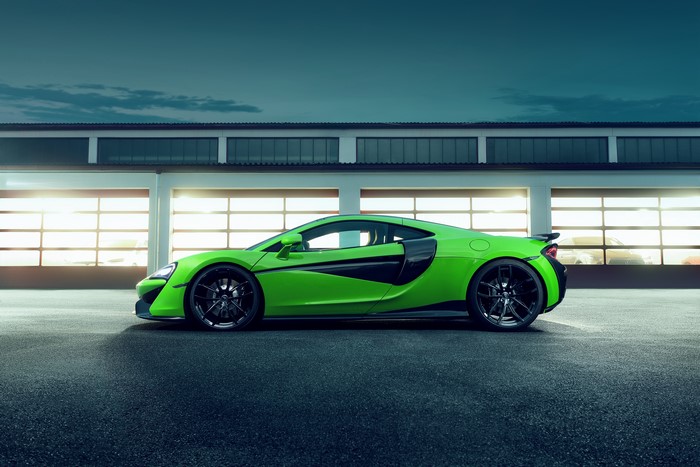 Green McLaren 570GT parked in front of garage