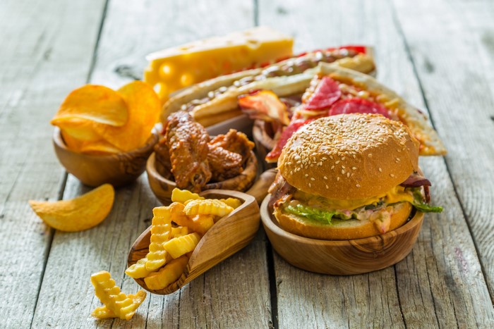 Fast food assortment: hamburger, fries, chips, wings, pizza, cheese