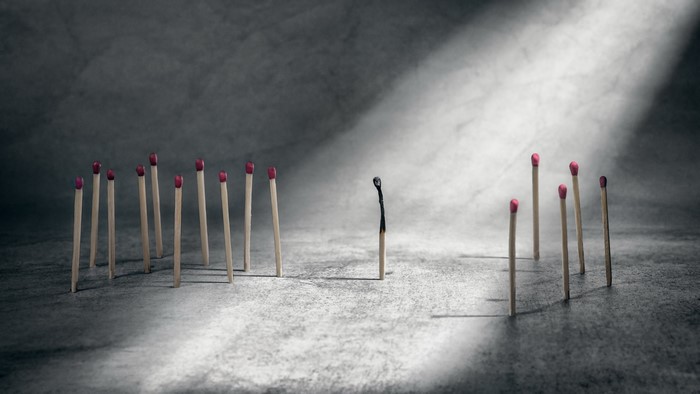 Burnt matchstick separated from unlit matches