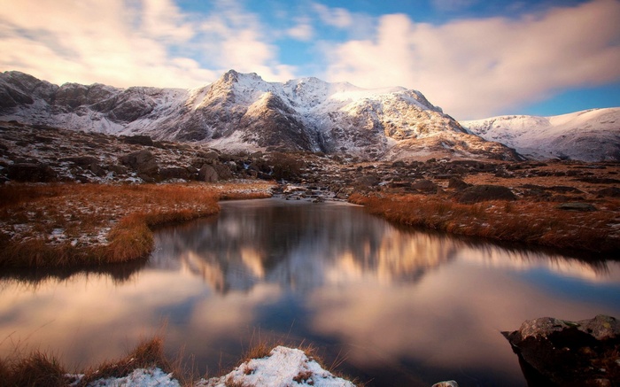 Snow-capped mountains reflected in a calm lake