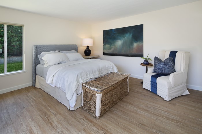 Bedroom with bed, armchair, and artwork