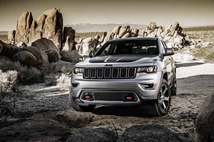 Silver Jeep Grand Cherokee in a rocky desert landscape