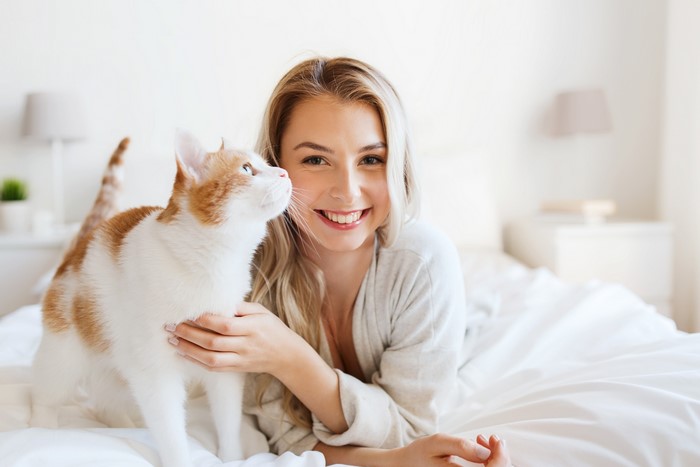 Blonde girl with cat on bed