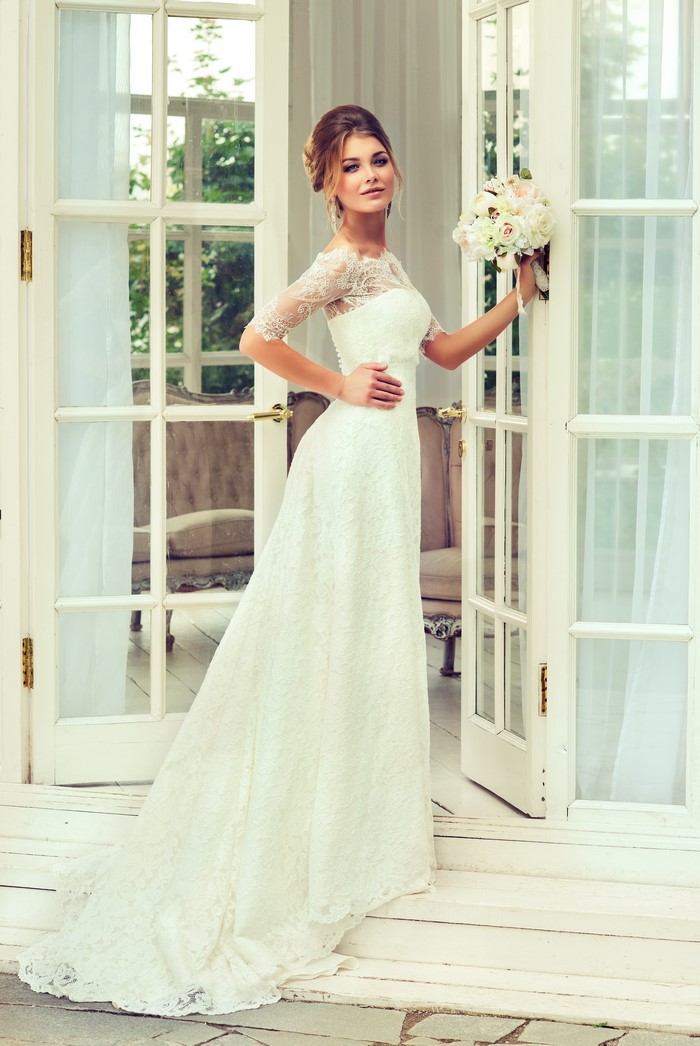 Bride in a white lace dress holding a bouquet