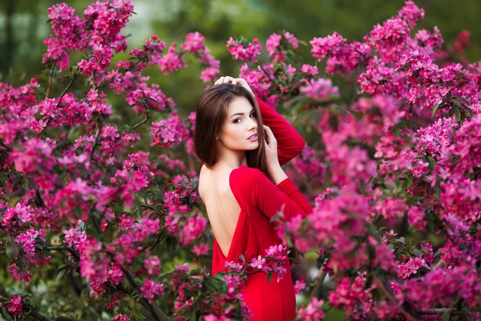 Woman in red dress among flowering trees