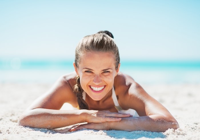 Woman lying on beach smiling