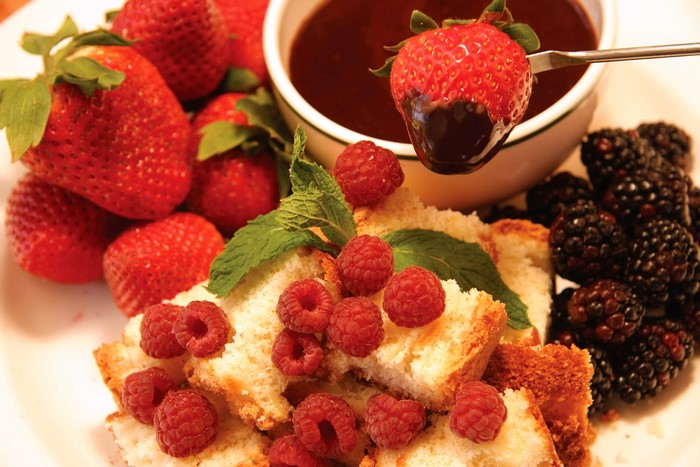 Chocolate-dipped strawberry with berries and cake