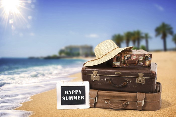 Summer beach with suitcases and hat