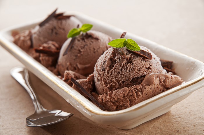 Chocolate ice cream scoops with mint and chocolate shavings