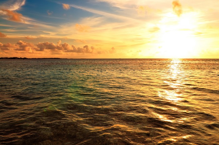 Sunset over the ocean with clouds and horizon