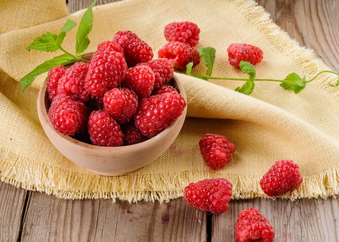 Raspberries in a bowl on a cloth