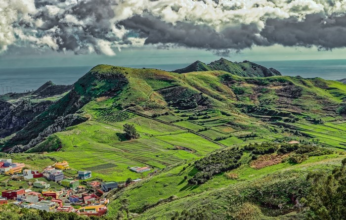 Colorful village on green hills overlooking the ocean in the Canary Islands