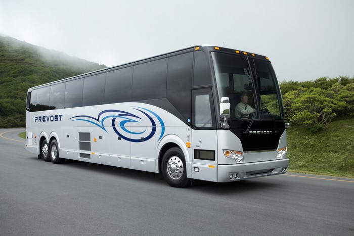 Silver Prevost H3-45 Bus Driving on a Winding Road