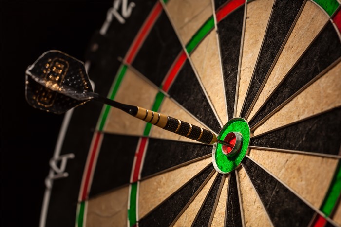Dart hitting bullseye on dartboard