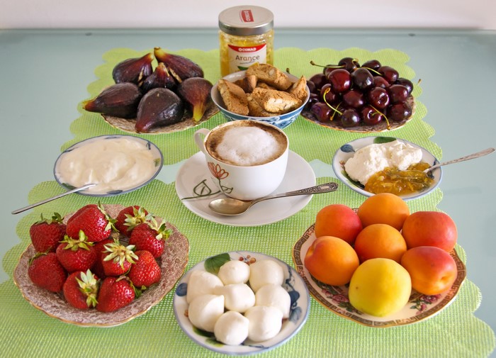 Breakfast spread with coffee, fruits, and pastries