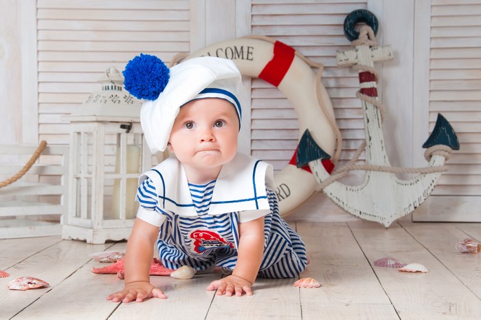 Baby in sailor uniform with nautical props